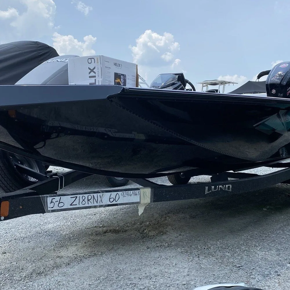 Black fiberglass fishing boat hull resting on a boat trailer