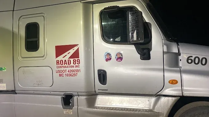 White semi truck cab door with Road 89 Corporation lettering and unit number 600, parked at night